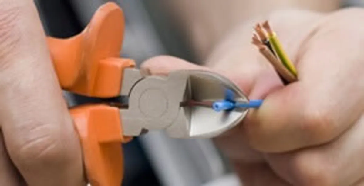 licensed electrician performing precise wire cutting and preparation during electrical service in Stockton, CA